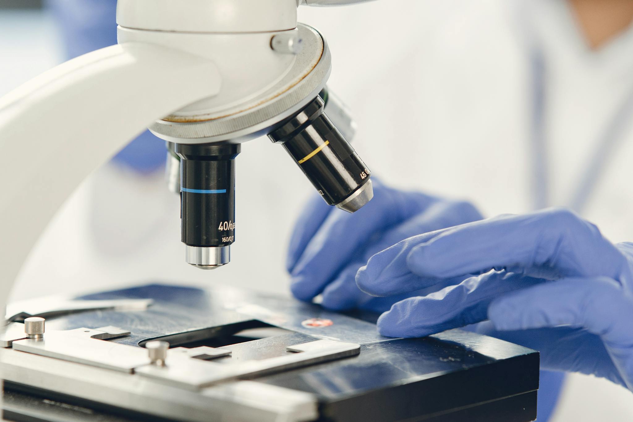Close-up view of a scientist examining a specimen under a microscope in a laboratory.