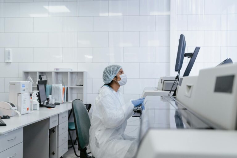 Scientist wearing protective gear conducts research in a modern lab setting.